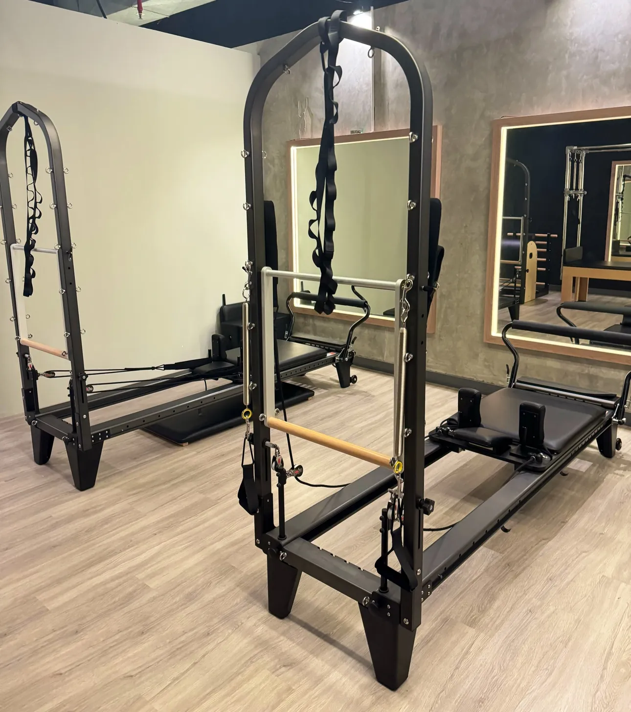 A Cadillac tower and reformer in the dark studio