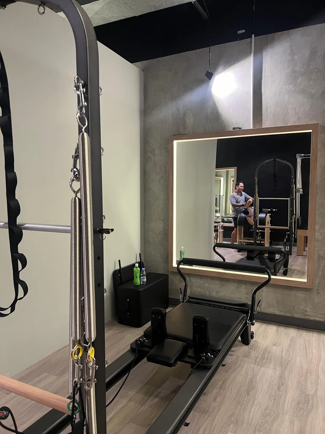 A reformer in front of the backlit mirror